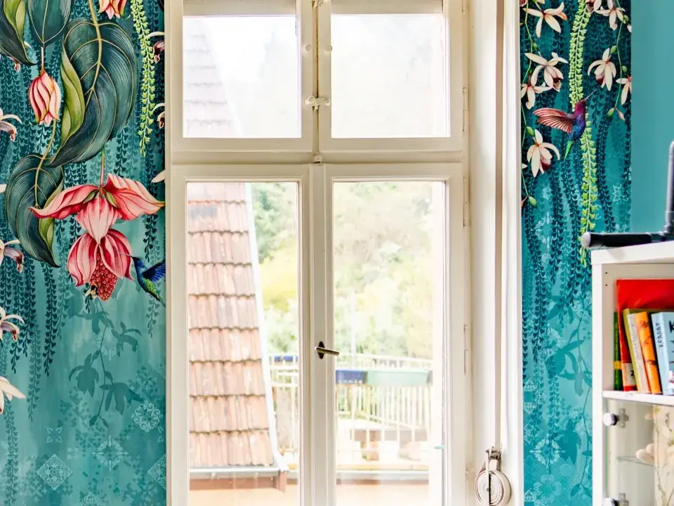Fenster neben einer Tapete mit Blüten- und Vogelmotiv