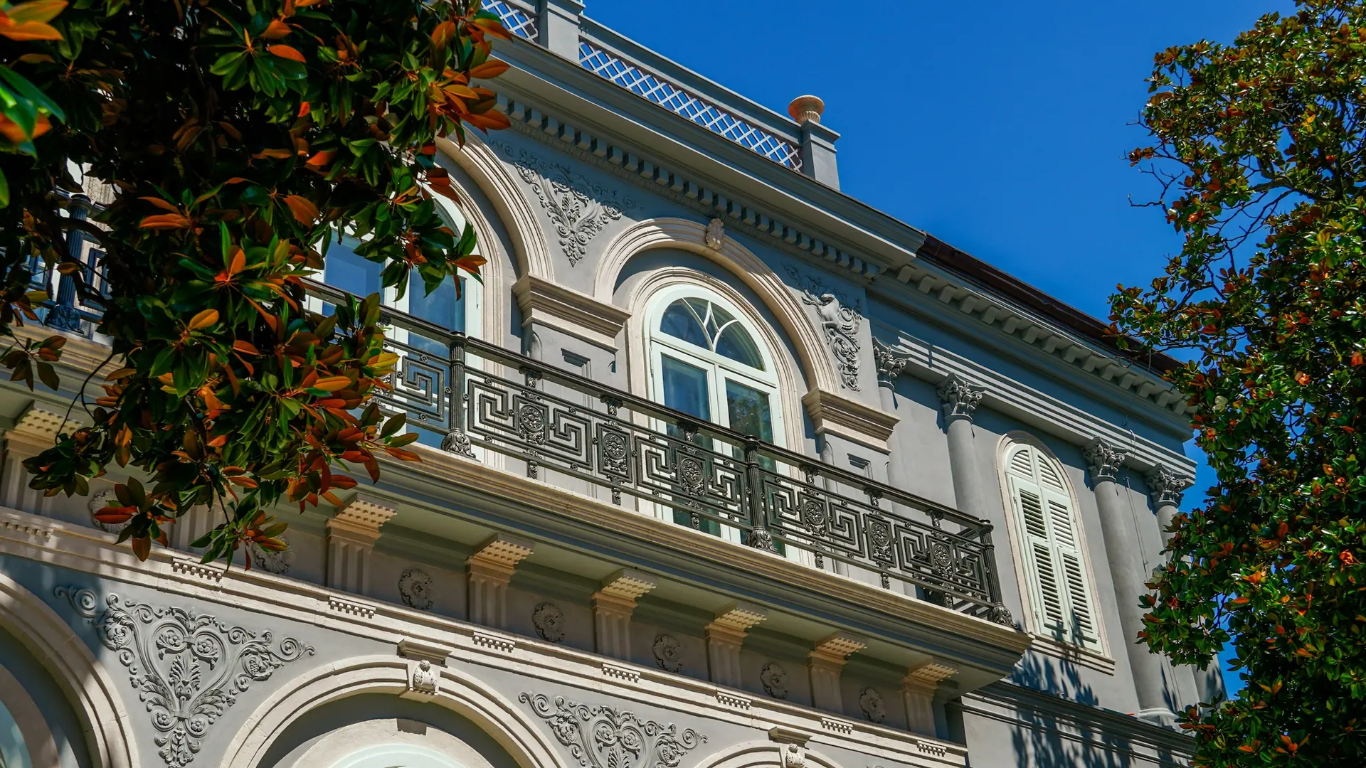 Altbau mit Stuckverzierungen, Balkongeländer und Rundbogenfenster